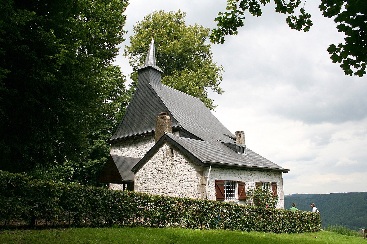 De kluizenaarskapel van Sint Thibaut, een oud huis dat uitzicht heeft over een groen landschap.